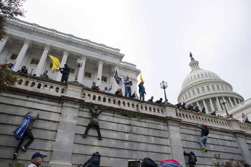 Support of President Donald Trump climb the west wall of the the U.S. Capitol on Wednesday, Jan. 6, 2021, in Washington. (AP Photo/Jose Luis Magana)