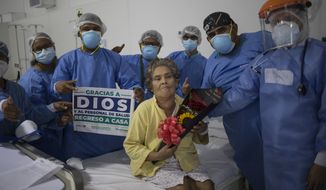 Doctors and nurses pose for a photo with COVID-19 patient Hilda Noriega, 76, to celebrate her recovery, at the Regional Hospital in Iquitos, Peru, Monday, March 22, 2021.(AP Photo/Rodrigo Abd)