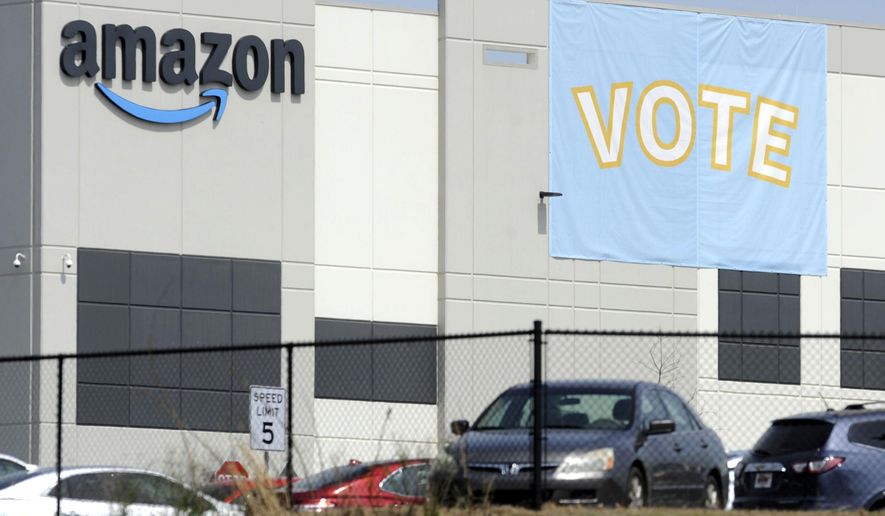 In this Tuesday, March 30, 2021, file photo, a banner encouraging workers to vote in labor balloting is shown at an Amazon warehouse in Bessemer, Ala. (AP Photo/Jay Reeves, File)
