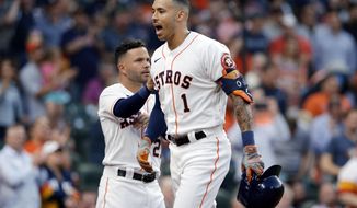Houston Astros&#x27; Jose Altuve, left, pats Carlos Correa (1) as they celebrate Correa&#x27;s home run during the second inning of a baseball game against the Oakland Athletics on Thursday, April 8, 2021, in Houston. (AP Photo/Michael Wyke)