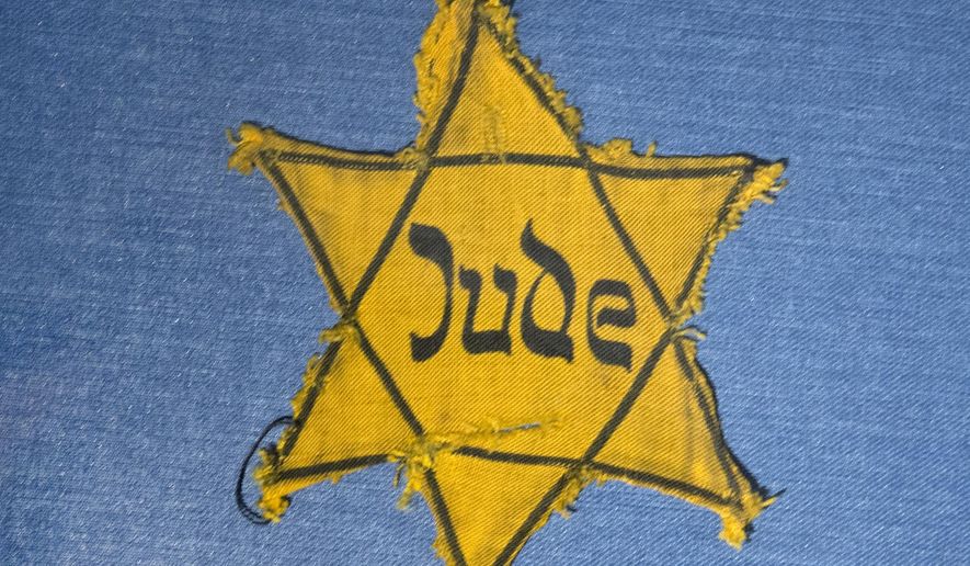 In this Wednesday, Jan. 22, 2014 file photo, the Yellow Star badge of Heinz-Joachim Aris (Dresden 1941) reading "Jew" is displayed in a showcase during a press preview in the new special exhibition "Shoes of the Dead — Dresden and the Shoah" at the Military History Museum in Dresden, Germany. (AP Photo/Jens Meyer, File)