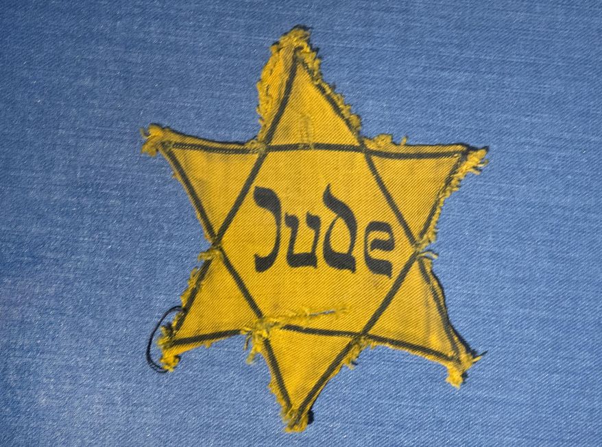 In this Wednesday, Jan. 22, 2014 file photo, the Yellow Star badge of Heinz-Joachim Aris (Dresden 1941) reading "Jew" is displayed in a showcase during a press preview in the new special exhibition "Shoes of the Dead — Dresden and the Shoah" at the Military History Museum in Dresden, Germany. (AP Photo/Jens Meyer, File)