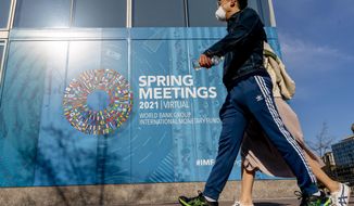 A poster is displayed on the International Monetary Fund building, Monday, April 5, 2021, in Washington. The IMF and the World Bank open their virtual spring meetings. (AP Photo/Andrew Harnik)