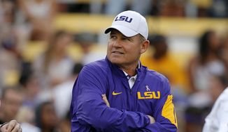 Then-LSU head coach Les Miles watches his team warm up before an NCAA college football game against Florida in Baton Rouge, La., in this Saturday, Oct. 17, 2015, file photo. In a $50 million federal racketeering lawsuit, an associate athletic director at LSU accuses university officials of retaliating against her for reporting racist remarks and inappropriate sexual behavior by former head football coach Les Miles. (AP Photo/Gerald Herbert, File) **FILE**