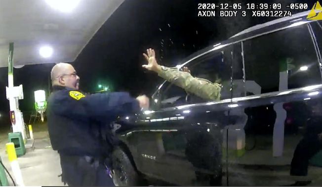 In this image made from Windsor, (Va.) Police video, A police officer uses a spray agent on Caron Nazario on Dec. 20, 2020, in Windsor, Va. Nazario, a second lieutenant in the U.S. Army, is suing two Virginia police officers over a traffic stop during which he says the officers drew their guns and pointed them at him as he was dressed in uniform. Caron Nazario says his constitutional rights were violated by the traffic stop in the town of Windsor in December.  (Windsor Police via AP)