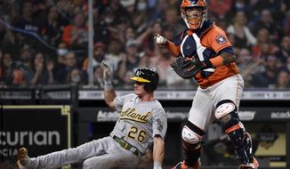 Houston Astros catcher Martin Maldonado, right, forces out Oakland Athletics&#x27; Matt Chapman (26) during the fourth inning of a baseball game, Friday, April 9, 2021, in Houston. Elvis Andrus was safe at first on a fielder&#x27;s choice. (AP Photo/Eric Christian Smith)