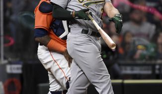 Oakland Athletics&#x27; Matt Olson, right, watches his three-run home run during the eighth inning of a baseball game against the Houston Astros, Friday, April 9, 2021, in Houston. (AP Photo/Eric Christian Smith)