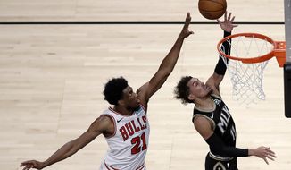 Atlanta Hawks&#x27; Trae Young, right, lays up a shot past Chicago Bulls&#x27; Thaddeus Young (21) during the first half of an NBA basketball game Friday, April 9, 2021, in Atlanta. (AP Photo/Ben Margot)