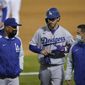 Los Angeles Dodgers&#39; Cody Bellinger, center, walks off the field as he leaves the game with manager Dave Roberts, left, and a trainer during the ninth inning of a baseball game against the Oakland Athletics in Oakland, Calif., Monday, April 5, 2021. (AP Photo/Jeff Chiu)
