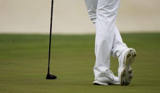 Is Woo Kim, of South Korea, leans on his 3 wood which he had to use to putt on the 16th green during the second round of the Masters golf tournament on Friday, April 9, 2021, in Augusta, Ga. (AP Photo/Matt Slocum)