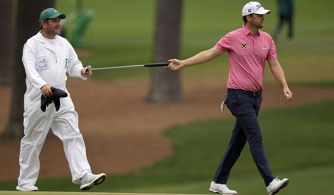 Bernd Wiesberger, of Austria, hands his putter to his caddie Jamie Lane after a birdie on the 15th hole during the second round of the Masters golf tournament on Friday, April 9, 2021, in Augusta, Ga. (AP Photo/David J. Phillip)