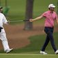 Bernd Wiesberger, of Austria, hands his putter to his caddie Jamie Lane after a birdie on the 15th hole during the second round of the Masters golf tournament on Friday, April 9, 2021, in Augusta, Ga. (AP Photo/David J. Phillip)