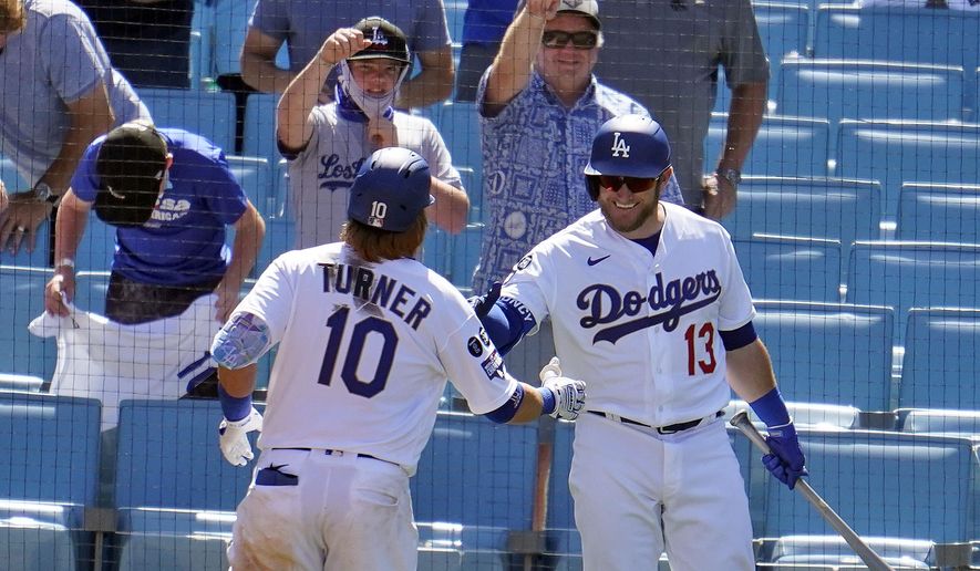 Los Angeles Dodgers&#x27; Justin Turner (10) is congratulated by Max Muncy (13) after hitting a solo home run in the sixth inning of a baseball game against the Washington Nationals, Friday, April 9, 2021, in Los Angeles. (AP Photo/Marcio Jose Sanchez)