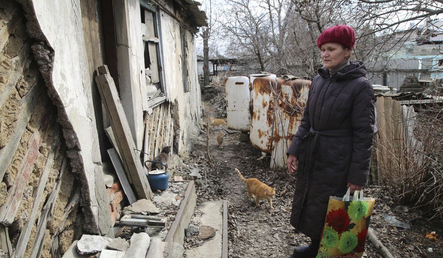 A woman visits her home in the separatist-controlled territory to collect her belongings after a recent shelling near a frontline outside Donetsk, eastern Ukraine, Friday, April 9, 2021. Tensions have built up in recent weeks in the area of the separatist conflict in eastern Ukraine, with violations of a cease-fire becoming increasingly frequent. (AP Photo)