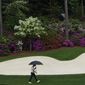 Justin Rose, of England, walks in the rain to the 13th green during the third round of the Masters golf tournament on Saturday, April 10, 2021, in Augusta, Ga. (AP Photo/Gregory Bull)