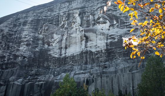 FILE - In this Oct. 5, 2020, a massive mountainside carving depicting Confederate leaders Jefferson Davis, Robert E. Lee and Stonewall Jackson is shown, in Stone Mountain, Ga.  In the shadow of the world’s largest memorial to the Confederacy, the City of Stone Mountain will host its first-ever Juneteenth celebration this summer. (AP Photo/Ron Harris, File)