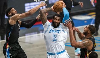 Los Angeles Lakers center Andre Drummond (2) grabs a rebound between Brooklyn Nets forward Bruce Brown, left, and center LaMarcus Aldridge during the first half of an NBA basketball game Saturday, April 10, 2021, in New York. (AP Photo/Corey Sipkin)