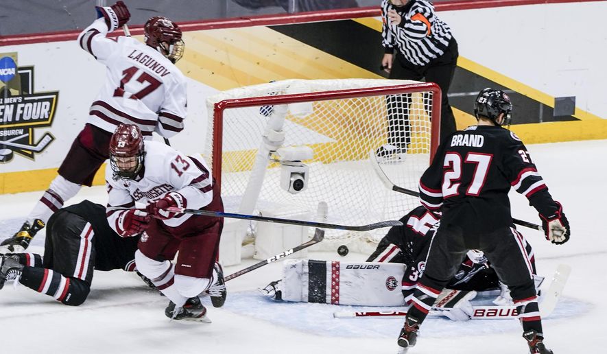 Massachusetts's Reed Lebster (13) celebrates after scoring against St. Cloud State during the first period of the NCAA men's Frozen Four hockey championship game in Pittsburgh, Saturday, April 10, 2021. (AP Photo/Keith Srakocic)
