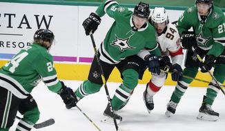 Dallas Stars&#39; Roope Hintz (24), Jamie Oleksiak (2) and Jason Robertson (21) combine to control the puck in front of Florida Panthers left wing Ryan Lomberg (94) in the first period of an NHL hockey game in Dallas, Saturday, April 10, 2021. (AP Photo/Tony Gutierrez)