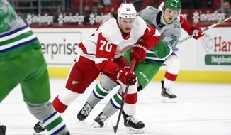 Detroit Red Wings&#x27; Troy Stecher (70) drives the puck after taking it away from Carolina Hurricanes&#x27; Steven Lorentz (78) during the first period of an NHL hockey game in Raleigh, N.C., Saturday, April 10, 2021. (AP Photo/Karl B DeBlaker)