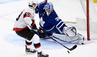 Ottawa Senators left wing Alex Formenton (59) looks for an opening on Toronto Maple Leafs goaltender Jack Campbell (36) during the first period of an NHL hockey game Saturday, April 10, 2021, in Toronto. (Frank Gunn/The Canadian Press via AP)