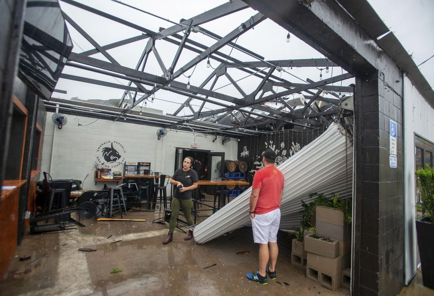 Employees assess the damage after the storm that came through Pensacola, Fla., and blew the roof off of Emerald Republic Brewing on Saturday, April 10, 2021. (John Blackie/Pensacola News Journal via AP)