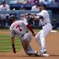 Washington Nationals&#39; Trea Turner, left, is forced out at second as Los Angeles Dodgers second baseman Gavin Lux attempts to throw out Juan Soto at first during the first inning of a baseball game Sunday, April 11, 2021, in Los Angeles. Soto was safe at first on the play. (AP Photo/Mark J. Terrill)