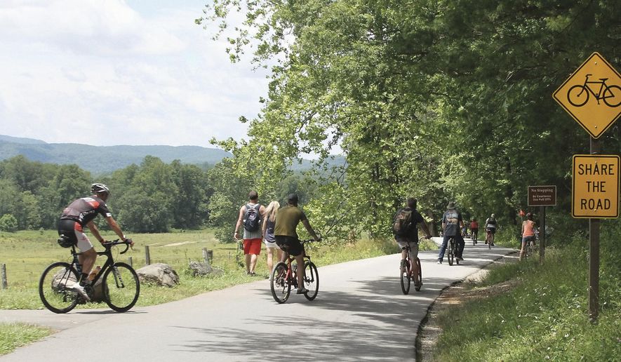 FILE - In this June 24, 2020 file photo, bicyclists start the ride around the Cades Cove Loop Road in The Great Smoky Mountains National Park, in Tenn. The outdoors has offered comfort and escape for many Southerners this year. The sudden isolation of being cut off from family, co-workers, and friends during the pandemic has driven more people to nature as an escape from the confines of the living room. (Tom Sherlin/The Daily Times via AP)