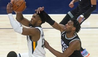 Utah Jazz guard Donovan Mitchell, left, goes to the basket as Sacramento Kings guard Buddy Hield, right, defends in the second half during an NBA basketball game Saturday, April 10, 2021, in Salt Lake City. (AP Photo/Rick Bowmer)