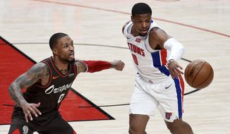 Detroit Pistons guard Dennis Smith Jr., right, pokes the ball away from Portland Trail Blazers guard Damian Lillard during the first half of an NBA basketball game in Portland, Ore., Saturday, April 10, 2021. (AP Photo/Steve Dykes)