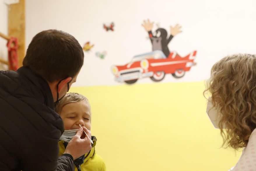 A young boy undergoes rapid COVID-19 test before entering his class at a kindergarten in Prague, Czech Republic, Monday, April 12, 2021. The Czech government has agreed to start easing the tight lockdown in one of the hardest-hit European countries and has given a green light for at least some children to return to schools. (AP Photo/Petr David Josek)