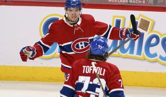 Montreal Canadiens&#39; Nick Suzuki celebrates his goal against the Toronto Maple Leafs with teammate Tyler Toffoli during the first period of an NHL hockey game in Montreal on Monday, April 12, 2021. (Paul Chiasson/The Canadian Press via AP)