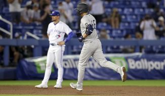 New York Yankees&#39; Kyle Higashioka rounds the bases after his home run as Toronto Blue Jays third baseman Cavan Biggio looks on during the eighth inning of a baseball game Monday, April 12, 2021, in Dunedin, Fla. (AP Photo/Mike Carlson)
