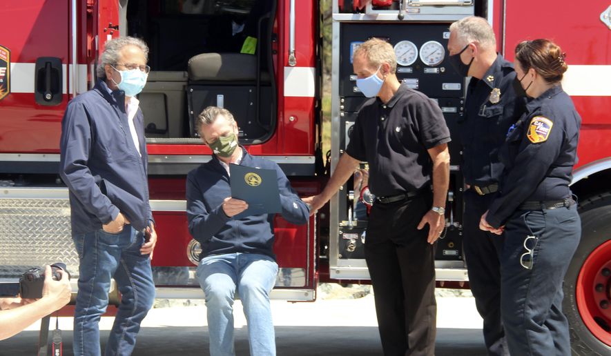 California Gov. Gavin Newsom signs the legislation into law that authorizes more than half a billion in new spending to prepare for wildfire season on Tuesday, April 13, 2021, at the Loafer Creek State Recreation Area in Oroville, Calif. California is racing to spend more than a half-billion dollars before this year's wildfire season gets going in earnest. Newsom on Tuesday approved the early funding. (AP Photo/Adam Beam)