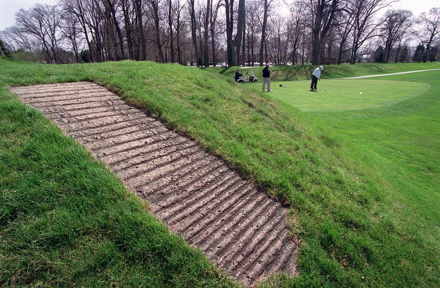 FILE - This April 6, 2000 file photo shows a concrete walkway, foreground, that allows golfers access to the top of an ancient American Indian mound at Moundbuilders Country Club in Newark, Ohio. The Ohio Supreme Court is scheduled to hear oral arguments Tuesday, April 13, 2021 in the debate over public access to the set of ancient ceremonial and burial earthworks. The case pits the state historical society against the country club where the earthworks are located. (Jeff Adkins/The Columbus Dispatch via AP, File)