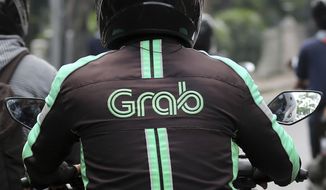 FILE - In this July 24, 2017, file photo, a GrabBike driver rides on his motorbike in Jakarta, Indonesia. Southeast Asia’s largest ride-hailing company, Grab Holdings, said Tuesday, April 13, 2021 that it plans to merge with U.S.-based Altimeter Growth Capital in a deal that would value it at nearly $40 billion in preparation for an initial public offering in the U.S. (AP Photo/Tatan Syuflana, File)