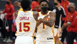 Atlanta Hawks center Clint Capela (15) and forward Nathan Knight (1) celebrate their win over the Toronto Raptors during an NBA basketball game Tuesday, April 13, 2021, in Tampa, Fla. (AP Photo/Chris O&#x27;Meara)