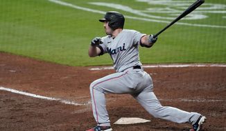 Miami Marlins&#39; Adam Duvall follows through on a two-run double during the fourth inning of the team&#39;s baseball game against the Atlanta Braves on Tuesday, April 13, 2021, in Atlanta. (AP Photo/John Bazemore)