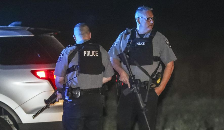 Villa Rica police block Highway 61 at East Bay Springs Drive after three metro Atlanta officers were injured Monday, April 12, 2021, after a police chase entered Carroll County, Ga., and a passenger fired multiple rounds with a rifle, officials said. Georgia authorities said one suspect was killed and the other arrested following the chase. (John Spink/Atlanta Journal-Constitution via AP)