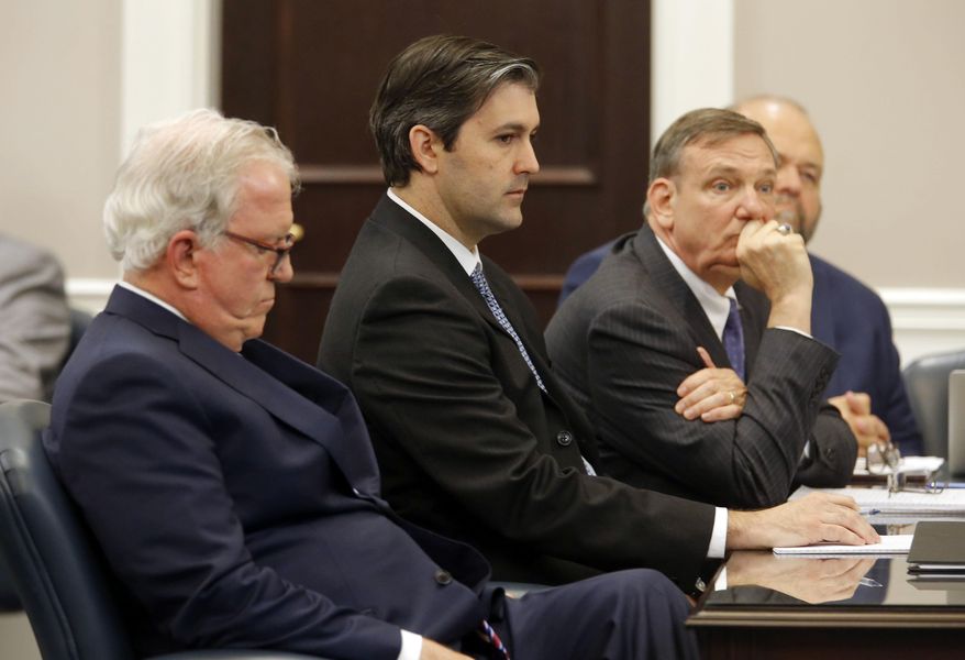 FILE - In this Dec. 5, 2016 file photo, defense attorneys Andy Savage, left, Don McCune, and Miller Shealy, right, sit around former North Charleston police officer Michael Slager at theCharleston County court in Charleston, S.C. Slager, who is serving 20 years in prison for killing an unarmed Black man who was running away from a traffic stop, said his lawyer never told him about a plea offer from prosecutors that could have cut years off his sentence and is asking for a new sentence in federal court this week.  (Grace Beahm/Post and Courier via AP, Pool)