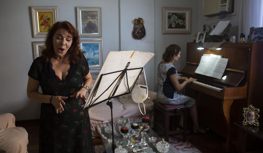 Municipal Theatre soprano opera singer Georgia Szpilman practices at her coach&#x27;s home during the COVID-19 pandemic in Rio de Janeiro, Brazil, Thursday, March 25, 2021. Szpilman used to perform in the city’s majestic municipal theater that has been closed for over a year, but because she is technically a public servant, she was able to keep her salary from Rio’s state government while performing online. (AP Photo/Bruna Prado)