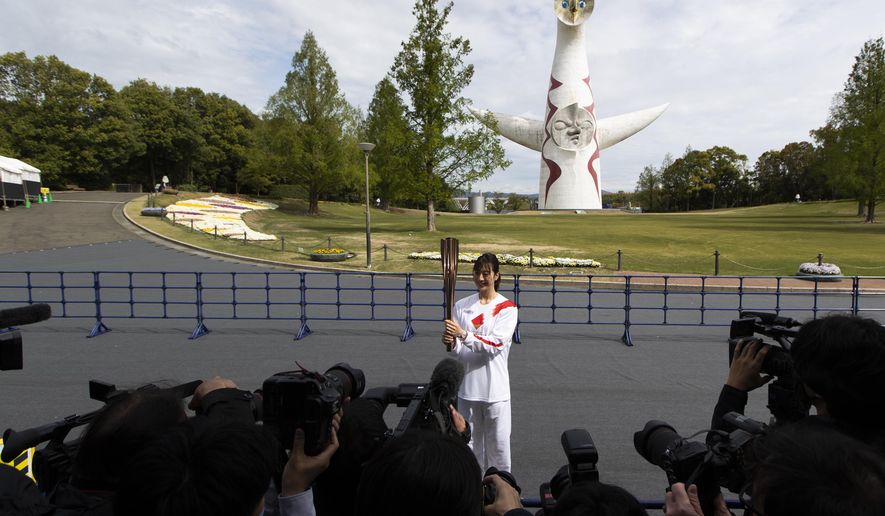 Former Olympian Aya Terakawa, participating as an Olympic torch relay runner, poses for the media before she carries the torch during the first day of the Osaka round at a former Expo site in Suita, north of Osaka, western Japan, Tuesday, April 13, 2021. The Tokyo 2020 Olympic kick-off event which was rescheduled due to the coronavirus outbreak was yet rearranged to hold at the former Expo park, instead of public streets, to close off the audience from the even, following the mayor&#x27;s decision as Osaka has had sharp increases in daily cases since early March. (AP Photo/Hiro Komae)