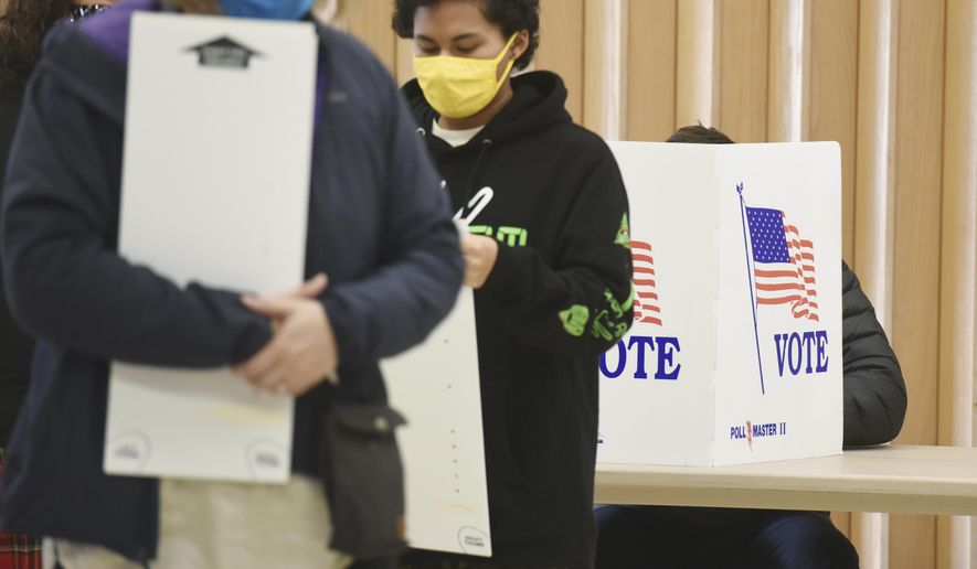 FILE - In this Nov. 3, 2020 file photo, residents wear masks as they vote at the Zion St. Joe United Church of Christ on Election Day, in St. Joseph, Mich. The leaders of three-dozen major Michigan-based companies, including General Motors and Ford, announced Tuesday, April 13, 2021, their opposition to Republican-sponsored election bills that would make it harder to vote in Michigan and other states. (Don Campbell/The Herald-Palladium via AP, File)