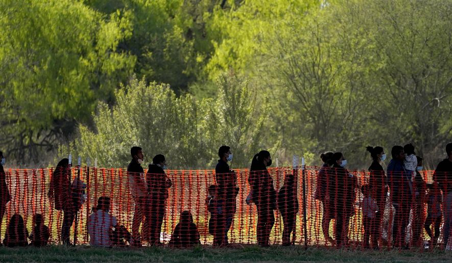 Migrants with children are seen in custody at a U.S. Customs and Border Protection processing area in Mission, Texas, in mid-March. (Associated Press)