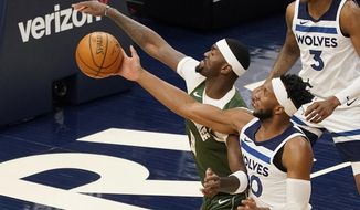 Minnesota Timberwolves&#39; Josh Okogie, right, breaks up a shot attempt by Milwaukee Bucks&#39; Bobby Portis in the first half of an NBA basketball game Wednesday, April 14, 2021, in Minneapolis. (AP Photo/Jim Mone)