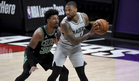 Portland Trail Blazers guard Damian Lillard, right, looks to drive the ball on Boston Celtics guard Marcus Smart, left, during the first half of an NBA basketball game in Portland, Ore., Tuesday, April 13, 2021. (AP Photo/Steve Dykes)