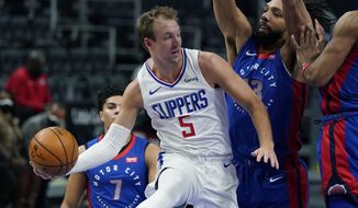 LA Clippers guard Luke Kennard (5) passes as Detroit Pistons center Jahlil Okafor (13) defends under the basket during the first half of an NBA basketball game, Wednesday, April 14, 2021, in Detroit. (AP Photo/Carlos Osorio)
