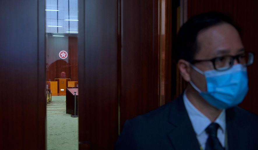 The logo of Hong Kong Special Administrative Region is seen through the glass of a closed door after the first and second reading of "Improving Electoral System (Consolidated Amendments) Bill 2021" finished at the Legislative Council in Hong Kong Wednesday, April 14, 2021. Hong Kong’s electoral reform bill was introduced in the city’s legislature on Wednesday, setting in motion changes that will give Beijing greater control over the process while reducing the number of directly elected representatives. (AP Photo/Vincent Yu)
