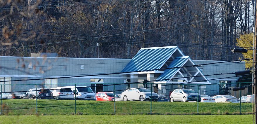 Vehicles are parked outside the Pennsylvania International Academy dorms, Wednesday, April 14, 2021, in Summit Township, Pa., which is housing a group of migrant children, about 146 girls ages 7-12, who were detained at the U.S.-Mexico border. The girls were flown to Erie International Airport, then transported to the facility to receive temporary shelter. (Greg Wohlford/Erie Times-News via AP)