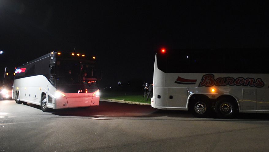 Three buses arrive at the Pennsylvania International Academy dorms Tuesday night, April 13, 2021, in Summit Township, Pa., carrying the a group of migrant children, 146 girls ages 7-12, detained at the U.S.-Mexico border. The girls were flown to Erie International Airport then transported to the facility to receive temporary shelter. (Greg Wohlford/Erie Times-News via AP) **FILE**